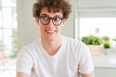 Yakışıklı delikanlı görünümlü yan ve dik dik bakma uzağa düşünce gülümseyen gözlüklü.