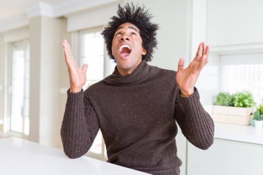 Afrikalı-Amerikalı adam kış kazak çılgın ve kızgın bağırarak ve agresif ifade ve silah kaldırdı bağırıyor. Hayal kırıklığı kavramı.