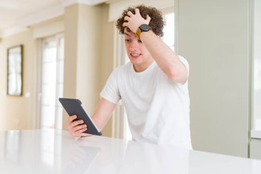 Genç adam kafasına, el ile vurguladı touchpad tablet kullanarak şok utanç ve sürpriz suratla, öfkeli ve sinirli. Korku ve hata için üzgün.