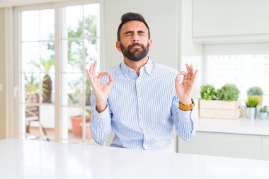 Yakışıklı İspanyol iş adamı rahatla ve gülümseyen gözlerle parmak ile meditasyon jest yapıyor kapalı. Yoga kavramı.