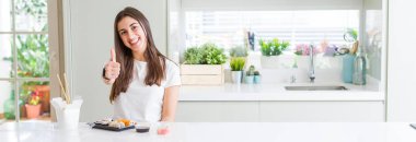 Güzel genç kadın hareketi el ile mutlu Yaşasın yapıyor teslimatından Asya suşi yemek geniş açı resim. Başarı gösteren kameraya bakarak ifade onaylama.