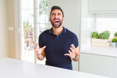 Yakışıklı İspanyol adam evde deli ve deli bağırarak ve agresif ifade ve silah kaldırdı bağırıyor. Hayal kırıklığı kavramı.