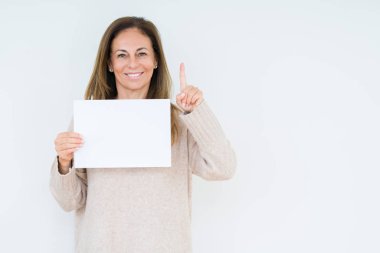 Bir fikir ya da soru işaret parmağı ile gülen yüz, bir numara boş kağıt sayfası izole arka plan üzerinde tutan orta yaş kadın şaşırttı