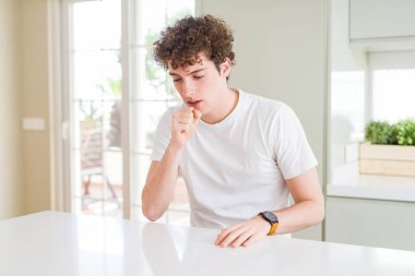 Evde beyaz t-shirt giyen genç yakışıklı adam hasta ve soğuk veya bronşit için semptom olarak öksürük duygu. Sağlık kavramı.