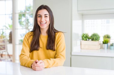 Yüzünde mutlu ve güzel bir gülümseme ile sarı kazak giyen güzel genç kadın. Şanslı kişi.