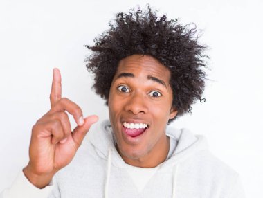 Afrikalı Amerikan beyaz izole bir fikirle sürpriz arka plan üzerinde dostum ya da gülen yüz, bir numara ile işaret parmağı soru