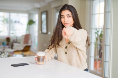 İşareti, pozitif ve kendinden emin bir jest ön el kamera ve size, parmak ile işaret genç kadın evde kahve içme
