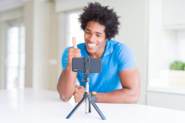 Ok işareti, başparmak ile parmak, mükemmel işareti yapıyor kocaman bir gülümseme ile smartphone mutlu kullanarak web kamerası ile online arama yapan Afro-Amerikan erkek