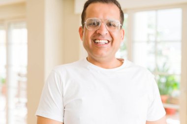 Evde kameraya gülümseyen gözlük takan orta yaş erkek