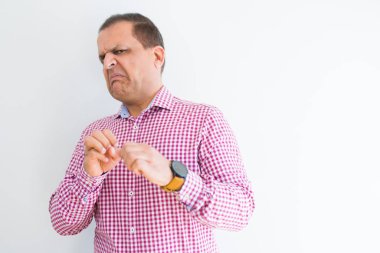 Middle age man wearing business shirt over white wall disgusted expression, displeased and fearful doing disgust face because aversion reaction. With hands raised. Annoying concept. clipart