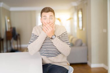 Evde bir kazak giyen genç yakışıklı adam kapsayan ağız elle hata için şok. Gizli kavramı.