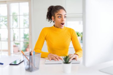 Genç Afro-Amerikan Kız şokta korktuğunu bir sürpriz yüz, korkuyor ve heyecanlı korku ifadesi ile bilgisayarla çalışma