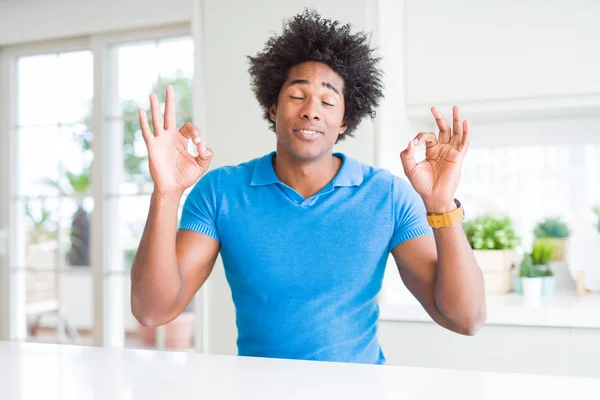 African American man at home relax and smiling with eyes closed doing meditation gesture with fingers. Yoga concept.