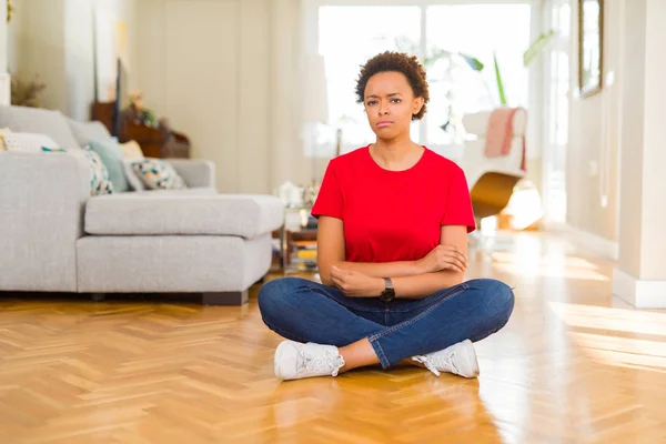 Joven Mujer Afroamericana Hermosa Sentada Suelo Casa Escéptica Nerviosa Frunciendo —  Fotos de Stock