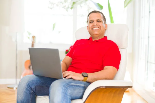 Evde kanepede otururken dizüstü kullanan orta yaş adam — Stok fotoğraf