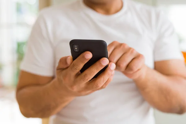 Primer plano de las manos de hombre de mediana edad utilizando el teléfono inteligente en casa —  Fotos de Stock