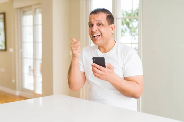 Hombre Mediana Edad Utilizando Teléfono Inteligente Casa Señalando Mostrando Con —  Fotos de Stock