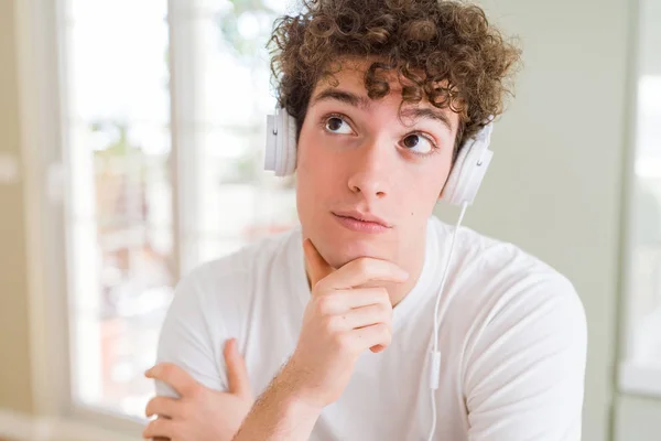 Giovanotto Che Ascolta Musica Indossando Cuffie Casa Con Mano Sul — Foto Stock