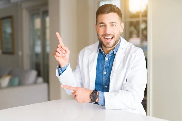 Joven Médico Guapo Clínica Sonriendo Mirando Cámara Apuntando Con Dos — Foto de Stock