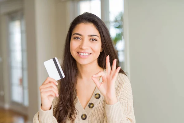 Junge Frau Hält Kreditkarte Als Zahlungsmittel Zeichen Mit Den Fingern — Stockfoto