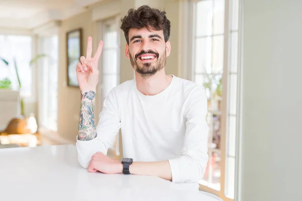 Hombre Joven Con Camisa Casual Sentado Mesa Blanca Sonriendo Con — Foto de Stock