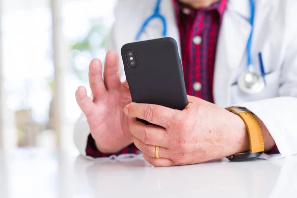 Zbliżenie na ręce człowieka lekarz za pomocą smartfona i noszenie stetho — Zdjęcie stockowe