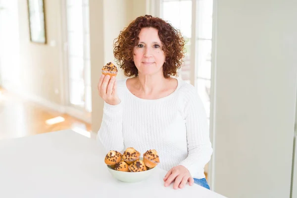Ανώτερος Γυναίκα Τρώει Σοκολάτα Τσιπ Muffins Αυτοπεποίθηση Έκφραση Στο Έξυπνο — Φωτογραφία Αρχείου