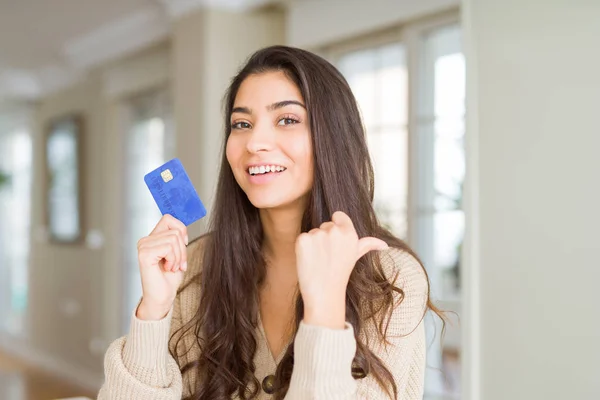 Junge Frau Hält Kreditkarte Als Zahlungsmittel Und Zeigt Mit Dem — Stockfoto