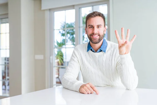 英俊的男人穿着休闲毛衣显示和指着手指四 而微笑着自信和快乐 — 图库照片