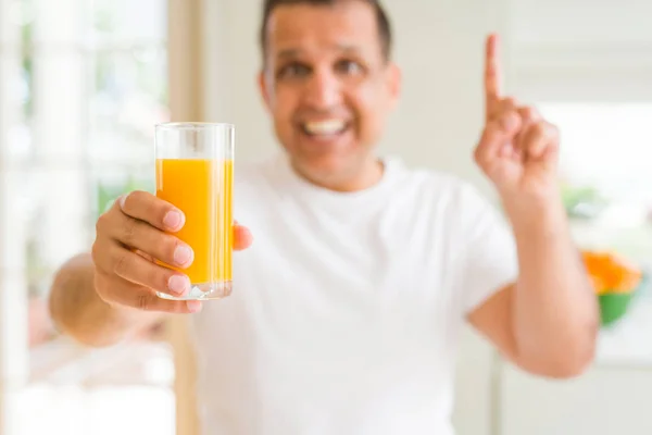 Mann Mittleren Alters Trinkt Ein Glas Orangensaft Hause Überrascht Mit — Stockfoto