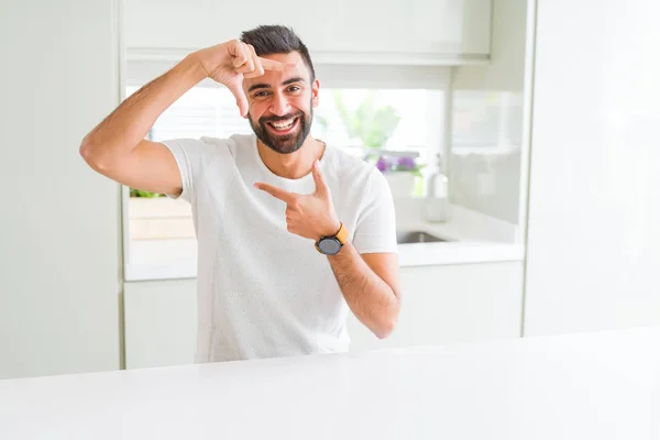 ハンサムなヒスパニック系の男の手でホーム笑顔作るフレームと幸せそうな顔で指で白い シャツ カジュアル 創造性と写真のコンセプト — ストック写真
