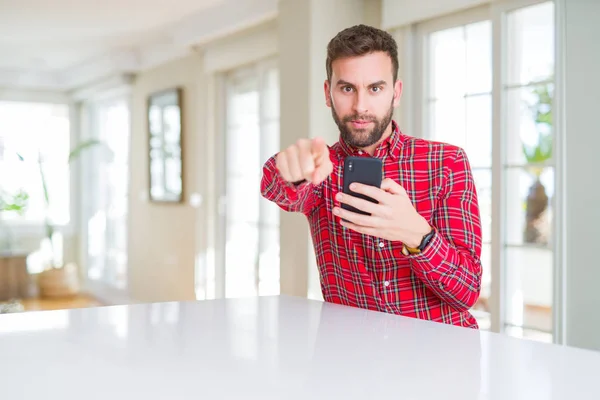 Hombre Guapo Usando Smartphone Apuntando Con Dedo Cámara Signo Mano —  Fotos de Stock