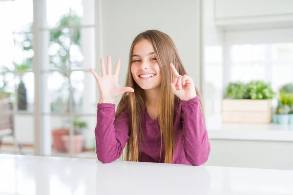 Красивая Девушка Ребенок Белом Столе Показывая Показывая Вверх Пальцами Номер — стоковое фото