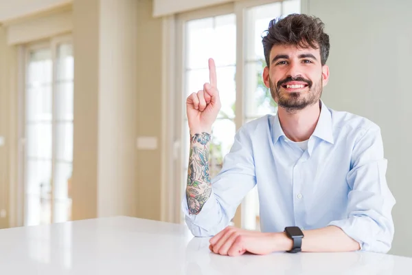 Joven Hombre Negocios Sentado Mesa Blanca Mostrando Señalando Hacia Arriba —  Fotos de Stock