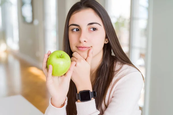 食べて健康的な青リンゴ フルーツ深刻な顔思考の質問についてを非常に美しい若い女性がアイデアを混乱 — ストック写真