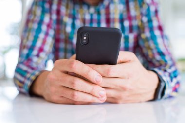 Smartphone kullanarak ve gülümseyen adam elinde yakın çekim