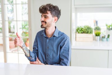 Jest tarafa genç adam gurur, seyir beyaz masaya oturan rahat gömlek giymiş yapıyor gülümseyen Yaşasın