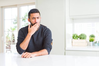 Evde rahat kazak giyen yakışıklı İspanyol adam el ağzıyla kapsayan yorgun esneme sıkılmış. Restless ve uyku hali.