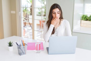 Laptop ve defter kapağı ağız elle utanç ile şok hata, korku, sessizlik içinde gizli kavramı korkmuş ifade için üniversite okuyan güzel genç öğrenci kadın