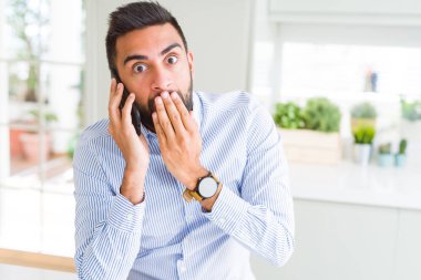 Hata, korku, sessizlik içinde gizli kavramı korkmuş ifade için utanç ile smartphone kapak ağız el ile konuşurken konuşmayı yakışıklı İspanyol iş adamı şok
