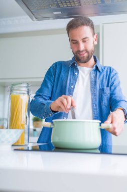 Evde makarna pişiren yakışıklı adam.