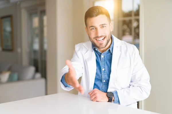 年轻英俊的医生在诊所微笑友好的提供握手作为问候和欢迎 成功的业务 — 图库照片
