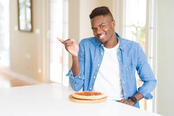 Africano Americano Homem Comendo Pizza Pepperoni Casa Muito Feliz Apontando — Fotografia de Stock