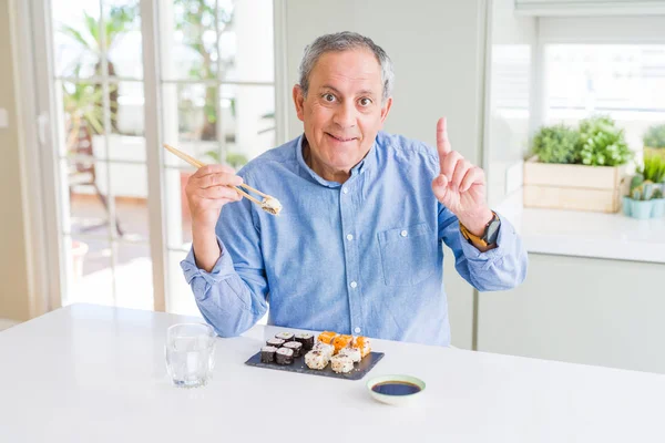 Hombre Mayor Guapo Comiendo Llevar Sushi Usando Palillos Casa Sorprendido — Foto de Stock