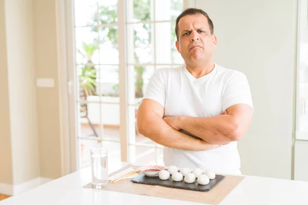 Hombre Mediana Edad Comiendo Albóndigas Asiáticas Casa Escéptico Nervioso Desaprobando — Foto de Stock