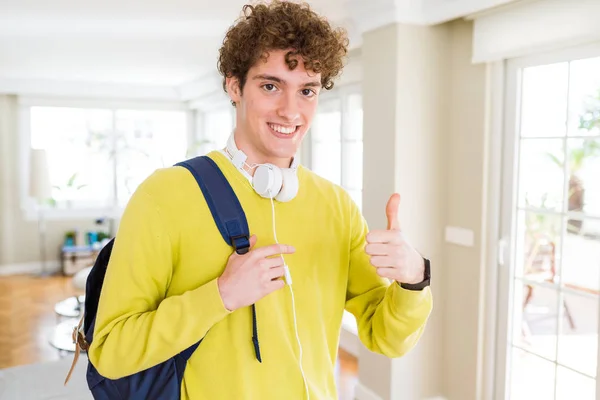 Młody Student Man Noszenia Słuchawek Plecak Happy Uśmiechem Robi Znak — Zdjęcie stockowe