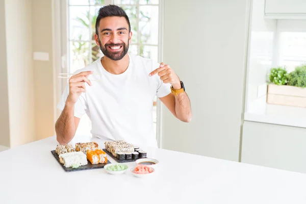 Przystojny Mężczyzna Hiszpanin Jedzenie Sushi Azjatycki Niespodzianka Twarzy Palcem Wskazującym — Zdjęcie stockowe