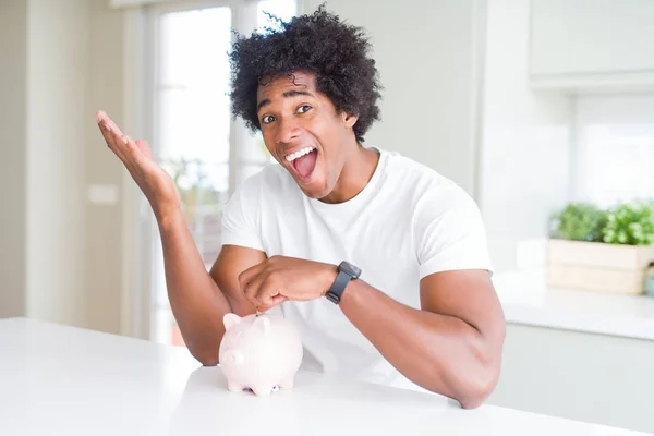 Hombre Afroamericano Poniendo Una Moneda Dentro Alcancía Muy Feliz Emocionado — Foto de Stock
