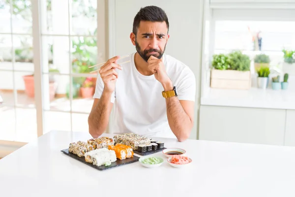 Hombre Hispano Guapo Comiendo Sushi Asiático Usando Palillos Cara Seria — Foto de Stock