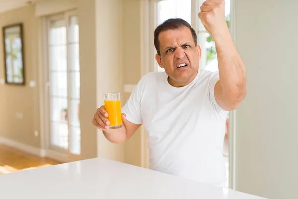 ホーム イライラと不満叫び狂気と上げられた手で 叫んで 怒りと怒りの概念でのオレンジ ジュースのガラスを飲む中年男性 — ストック写真